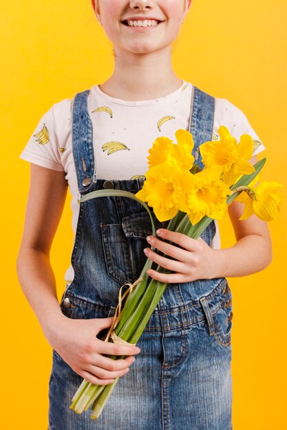 Nahaufnahmemädchen, das Blumen hält