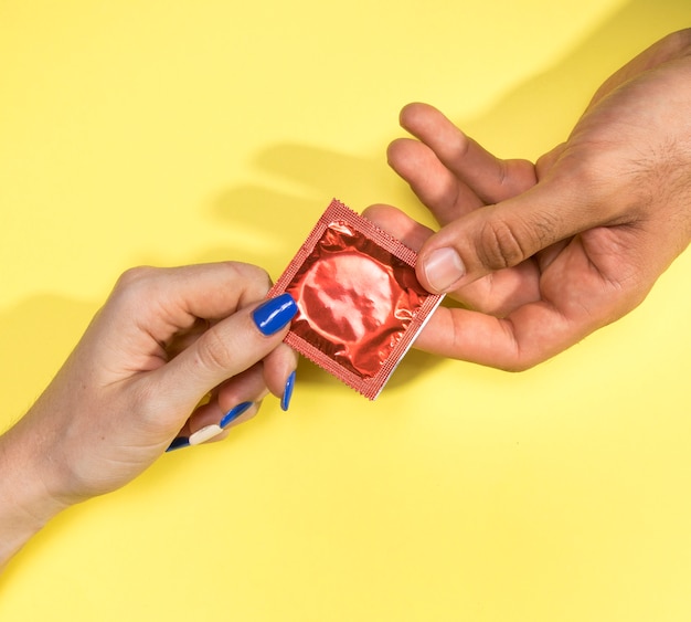 Nahaufnahmemann und -frau, die ein Kondom halten