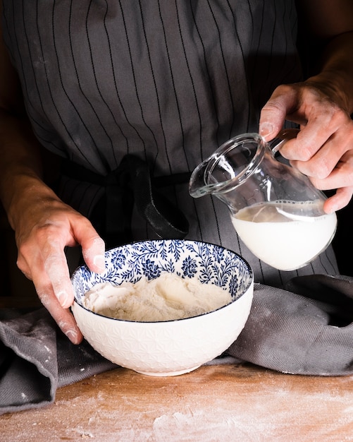 Nahaufnahmeperson bereit, Milch in Schüssel zu gießen