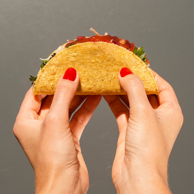 Nahaufnahmeperson mit Taco und grauem Hintergrund