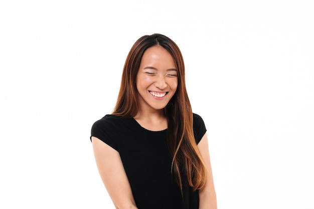 Nahaufnahmeporträt der lachenden attraktiven asiatischen Frau mit geschlossenen Augen lokalisiert auf Weiß
