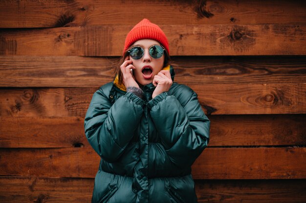 Nahaufnahmeporträt der schockierten Frau, die am Telefon spricht