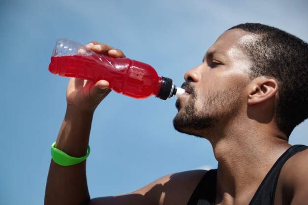 Nahaufnahmeporträt des jungen Mannes, der sich hydratisiert