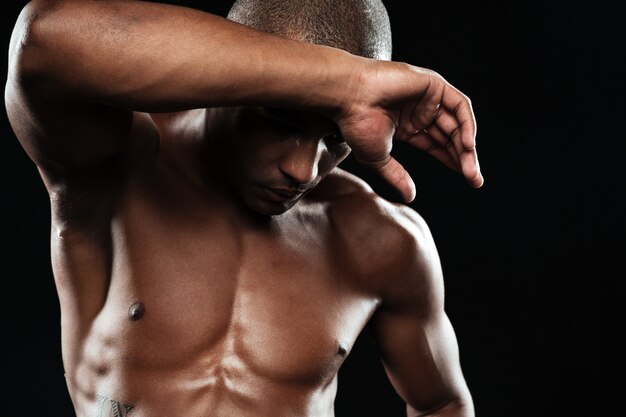Nahaufnahmeporträt des jungen muskulösen afroamerikanischen Sportmannes, der nach dem Training abkühlt