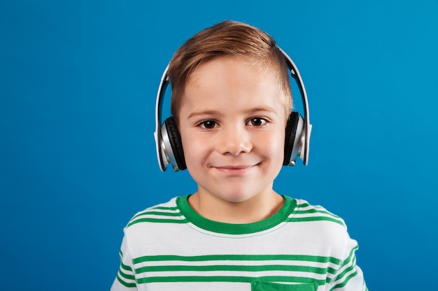 Kostenloses Foto nahaufnahmeporträt des lächelnden jungen, der musik durch kopfhörer hört