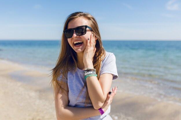 Nahaufnahmeporträt einer jungen hübschen Frau mit langen Haaren am Strand