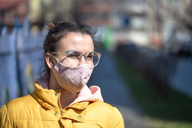 Nahaufnahmeporträt junge Frau in einer Maske während der Pandemie. Coronavirus (COVID-19 . Konzept der Gesundheitsversorgung während einer Epidemie oder Pandemie