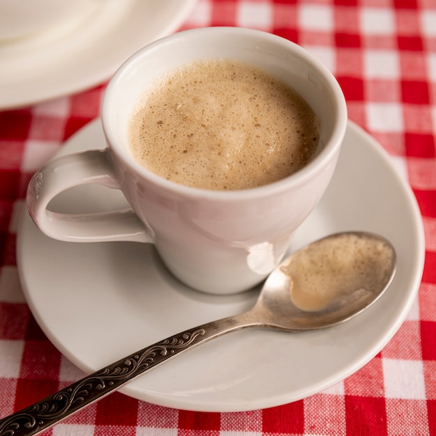 Nahaufnahmeschale Milchkaffee mit kariertem Hintergrund