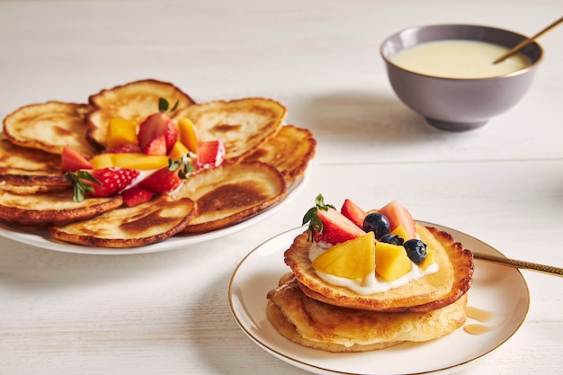 Nahaufnahmeschuss von köstlichen Pfannkuchen mit Früchten auf der Oberseite