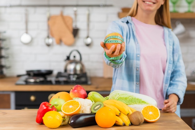 Nahaufnahmesmileymädchen, das einen Apfel hält