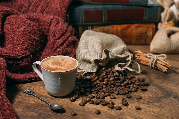 Nahaufnahmetasse kaffee mit gebratenen Bohnen