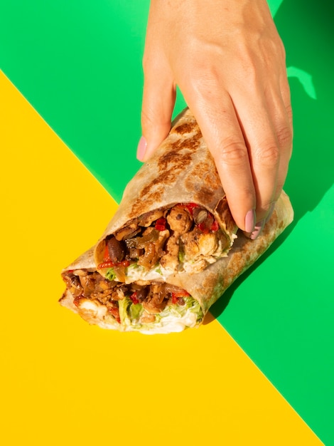 Kostenloses Foto nahaufnahmezusammenstellung mit burrito und buntem hintergrund