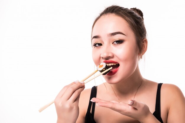 Nahes Porträt eines Frauengeschmacks isst Sushi-Rollen, die mit hölzernen Essstäbchen halten
