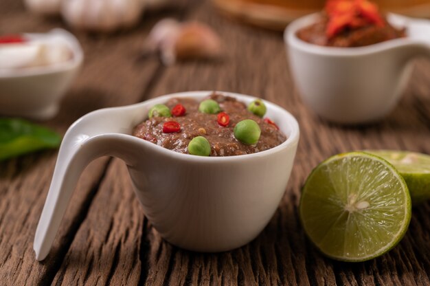 Nam Phrik Kapi mit Chili und Zitrone auf Holzboden.