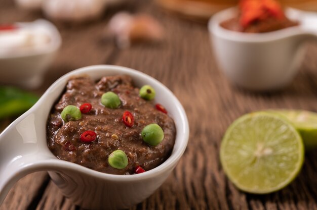 Nam Phrik Kapi mit Chili und Zitrone auf Holzboden.