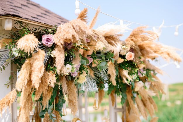 Natürliche Dekorationen mit Blumen der Hochzeitszeremonie wölben sich im Freien