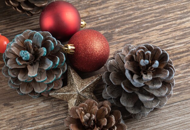Natürliche Eichenzapfen auf einem Holzdeck mit glitzernden Ornamenten herum
