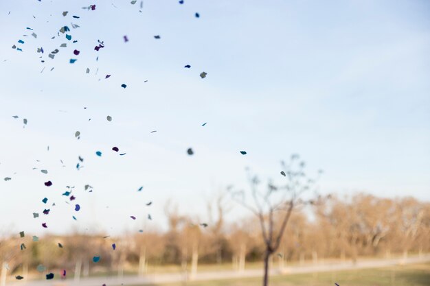 Natürliche Szene mit farbigen Papieren vom Himmel fallen