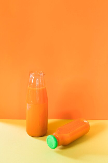 Natürlicher orange Smoothie in der Flasche auf Tisch