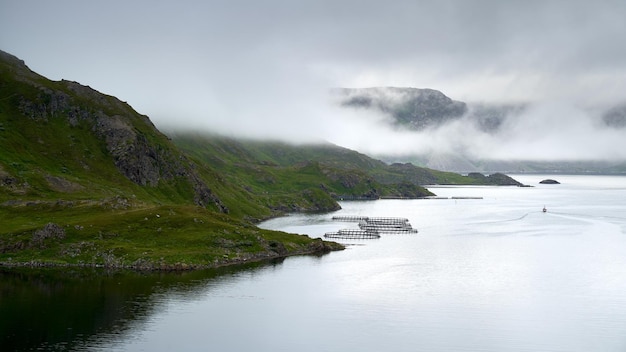 Neblige Küste mit Lachsfarmen im Norden Norwegens in der Nähe des Nordkaps