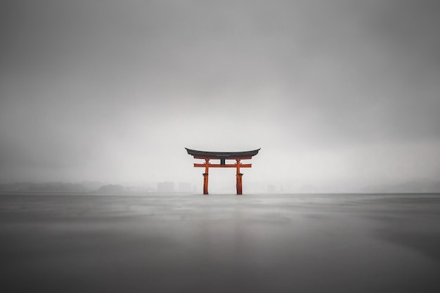 Nebliger Schuss der schwimmenden Torii von Miyajima, Japan während des Regens