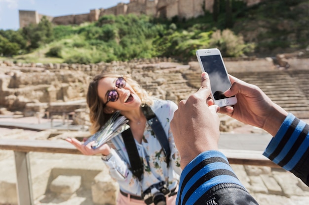 Nehmen des Fotos von lachen Freundin vor Denkmal