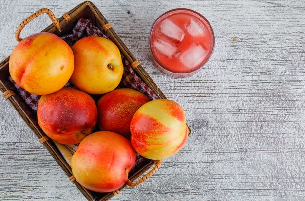 Nektarinen in einem Korb mit Saft flach lagen auf einer schmuddeligen Wand