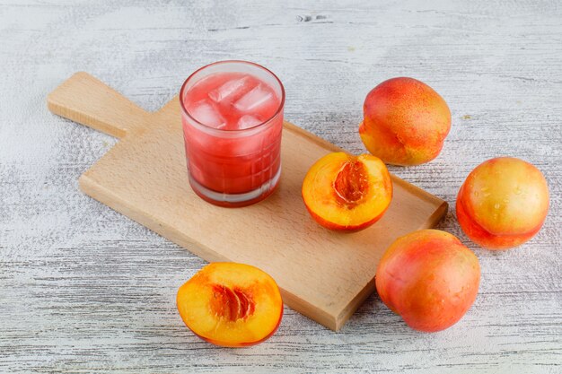 Nektarinen mit Saft auf grungy und Schneidebrett Tisch, hohe Winkelansicht.