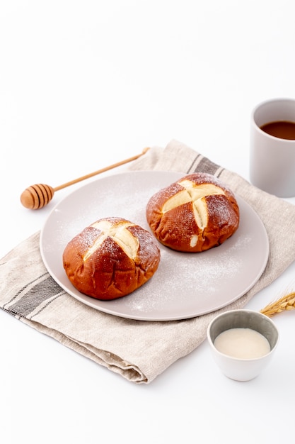 Nette Brötchen und Tasse Kaffee der hohen Ansicht auf Stoff