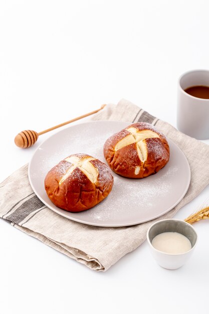 Nette Brötchen und Tasse Kaffee der hohen Ansicht auf Stoff