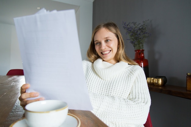 Nette Dame in den Untersuchungspapieren der weißen Strickjacke zu Hause