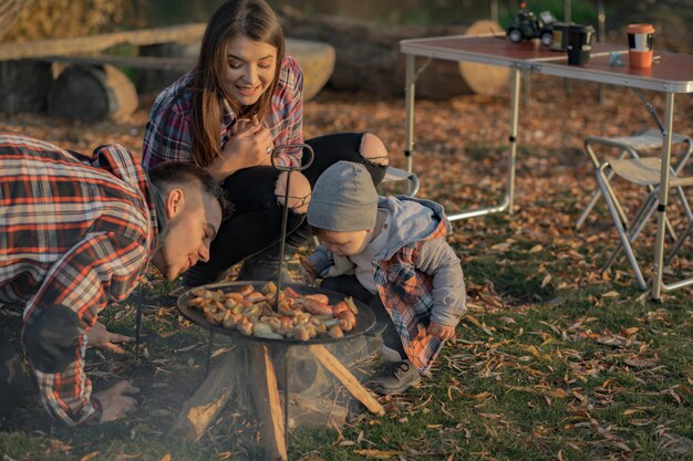 Nette Familie, die auf einem Picknick in einem Wald sitzt