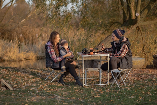 Nette Familie, die auf einem Picknick in einem Wald sitzt