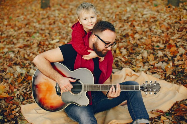 Nette Familie, die in einem Herbstpark spielt