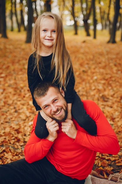 Nette Familie, die in einem Herbstpark spielt