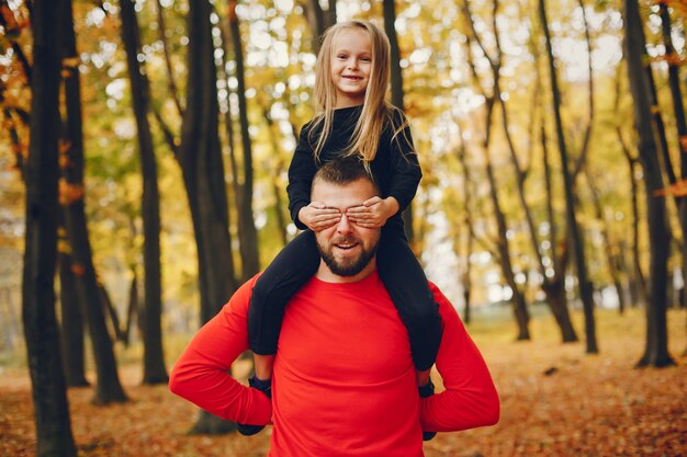 Nette Familie, die in einem Herbstpark spielt