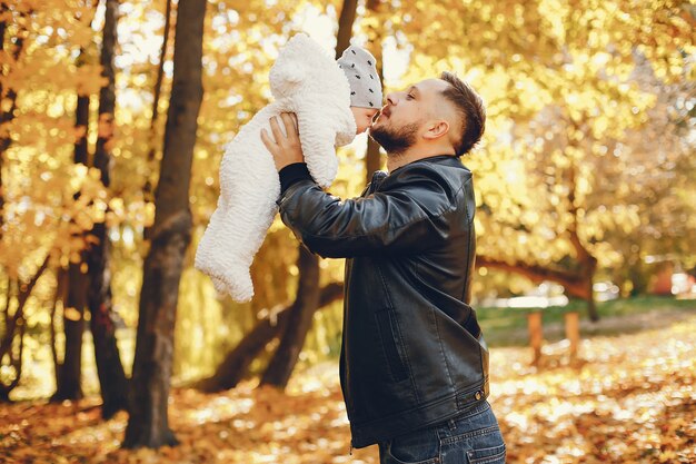 Nette Familie, die in einem Herbstpark spielt