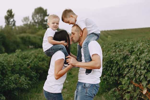 Nette Familie, die in einem Sommerfeld spielt