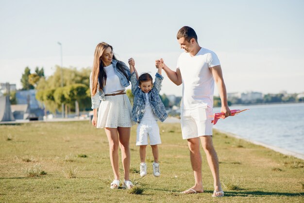 Nette Familie, die in einem Sommerpark spielt