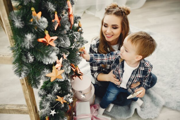 Nette Familie, die nahe Weihnachtsbaum sitzt