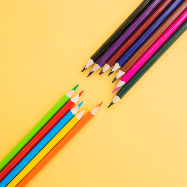Nette farbige Bleistifte auf gelbem Hintergrund
