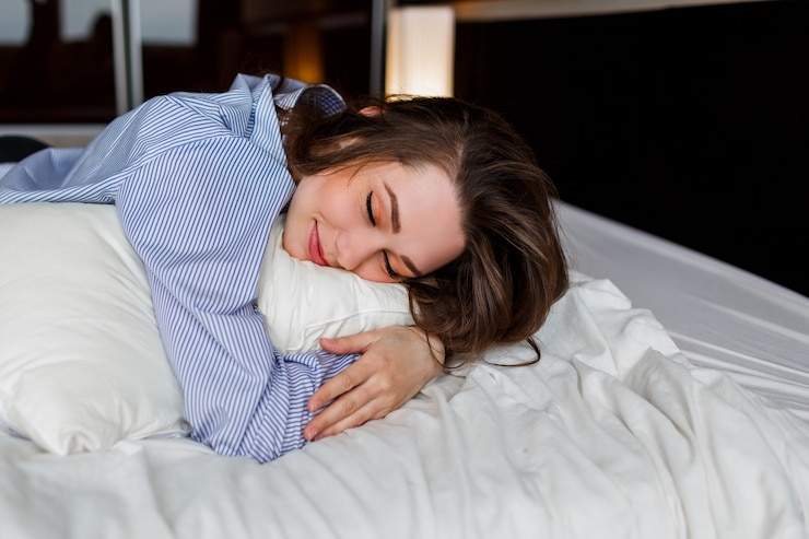 Kostenlose Foto nette frau, die auf ihrem bauch auf dem bett liegt und schläft. tragen von stilvollen schwarzen dessous und gestreiftem boyfriend-shirt.