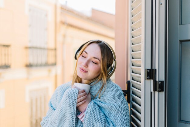 Nette Frau, die Musik auf Balkon genießt