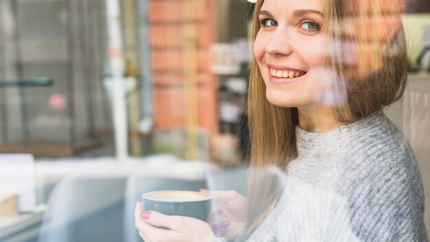 Nette Frau, die Tasse Kaffee hält