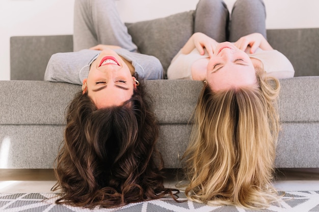 Nette Frauen, die auf Sofa liegen