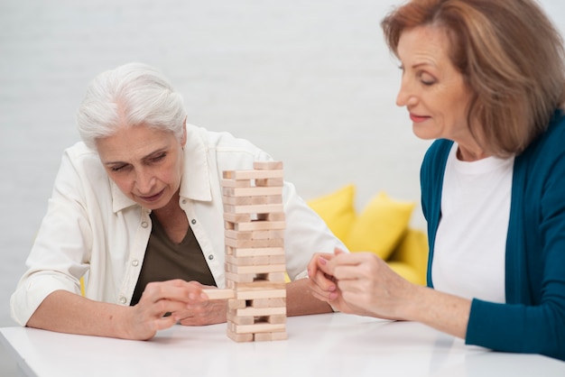 Nette Frauen, die zusammen jenga spielen