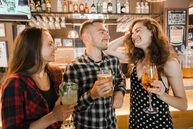 Nette Freunde, die den Abend genießen, trinkt in der Bar