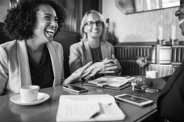 Nette Geschäftsfrauen, die an einem Café sich entspannen