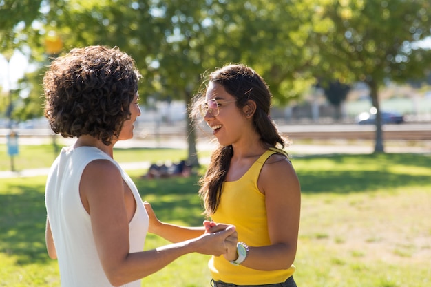 Nette junge Frauen, die im Park sprechen