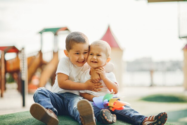 Nette kleine Jungen, die Spaß auf einem Spielplatz haben